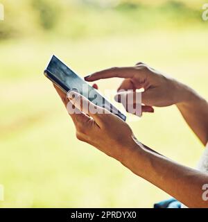 Shes hat viele Verbindungen hergestellt. Nahaufnahme einer unkenntlichen Frau, die ein Mobiltelefon im Freien benutzt. Stockfoto