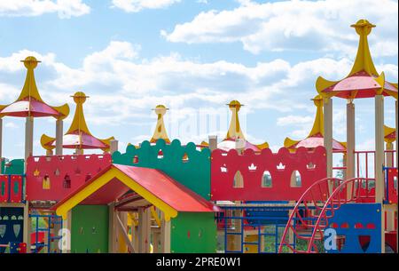 Moderner öffentlicher Spielplatz vor dem blauen Himmel. Ein farbenfroher Spiel- und Sportkomplex für Kinder ohne Menschen. Ausrüstung für Klettern und Angriff auf den Spielplatz. Stockfoto