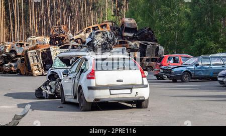 Erschossen, beschädigte Autos während des Krieges in der Ukraine. Das Zivilauto wurde beschädigt. Schrapnell und Einschusslöcher in der Karosserie. Das Auto ist voller Kugeln. Einschusslöcher und Schalenfragmente. Stockfoto