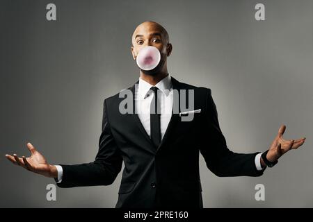 M Hier bleiben. Studioporträt eines hübschen jungen Geschäftsmannes vor grauem Hintergrund. Stockfoto