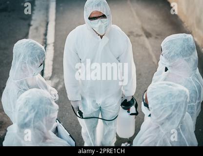 Covid-Pandemie-Ausbruchsteam aus Ärzten oder medizinischem Personal, die schützende psa tragen, um die Ausbreitung des Virus außerhalb zu verhindern. Gruppe von Wissenschaftlern, die Gefahrstoffanzug für Corona oder ebola-Krankheit auf der Straße tragen Stockfoto