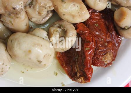 Pilze, sonnengetrocknete Tomaten, Oliven und Kapern in Olivenöl Stockfoto