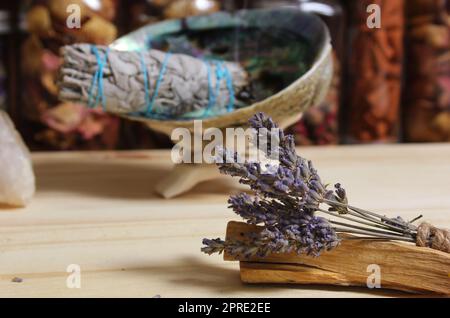 Getrockneter Lavendel mit Palo Santo Sticks und Abalone Shell zum Verschmieren im Hintergrund bei flachen Freiheitsgraden Stockfoto