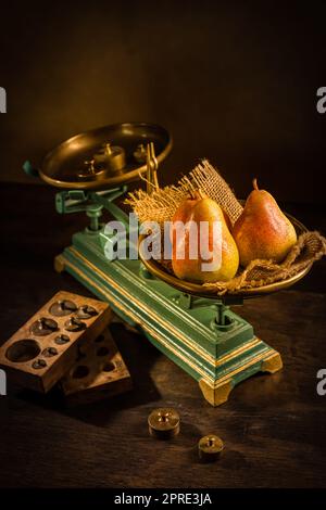 Organische Birnen auf alten Jahrgangswaagen mit Messinggewichten auf Holzhintergrund Stockfoto