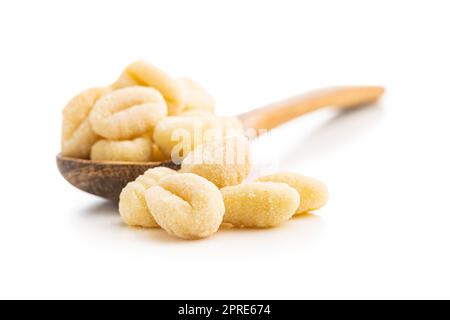 Ungekochte Kartoffelgnocchi in Holzlöffel isoliert auf weißem Hintergrund. Stockfoto
