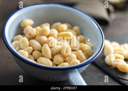 Ungekochte Kartoffelgnocchi in einem Sieb. Leckeres italienisches Essen. Stockfoto