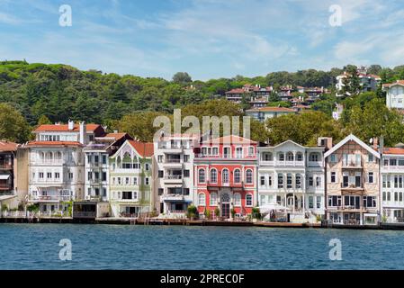 Blick vom Meer auf die grünen Berge der asiatischen Seite der Bosporus-Meerenge, mit traditionellen Häusern und dichten Bäumen an einem Sommertag Stockfoto