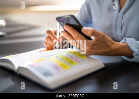 Kalenderplan In Papier Und Am Telefon Stockfoto