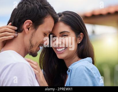 Hes, der Mann meiner Träume. Ein liebevolles junges Paar, das sich umarmt, während es draußen steht. Stockfoto