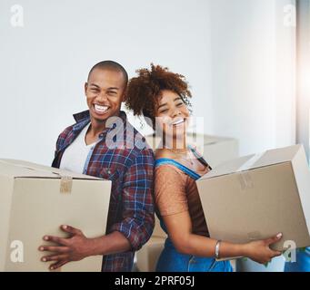 Fangen wir mit diesen Boxen an. Ein attraktives junges Paar zieht um. Stockfoto