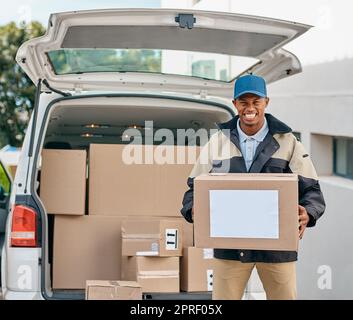 Er führt seine Auslieferungsrunden durch. Porträt eines Kuriers, der die Kartons aus einem Lieferwagen auslädt. Stockfoto