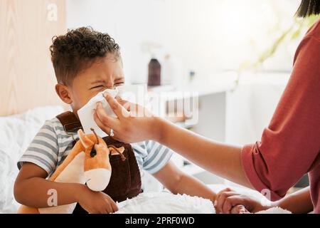 Grippe, krankes oder kaltes Kind mit Eltern, die niesen, blasen und laufende Nase abwischen, während sie krank mit Covid-Virus, Sinus und Allergie-Symptome im Bett zu Hause. Mutter, die sich um den stickigen und gestauchten kleinen Sohn kümmert Stockfoto