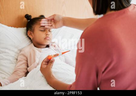 Covid, Pflege und krankes kleines Mädchen im Bett mit besorgter Mutter, die die Temperatur mit einem Thermometer prüft. Fürsorgliche Eltern sorgten sich um ihr Kind mit Fieber, Erkältung, Grippe und Müdigkeit Stockfoto