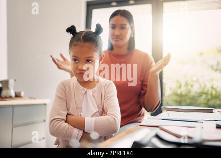 Aufgebracht, diszipliniert und familiär, beleidigt und stur, kleines Mädchen, das unglücklich mit ihrer schimpfenden Mutter im Hintergrund aussieht. Unartiges, problematisches und böses Kind, das wütend ist und ihre Eltern zu Hause ignoriert Stockfoto