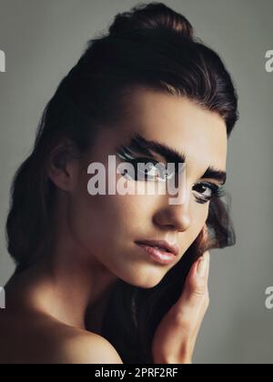 Habt keine Angst, euch selbst zu sein. Studioaufnahme einer attraktiven jungen Frau mit auffälligen Augen-Make-up. Stockfoto