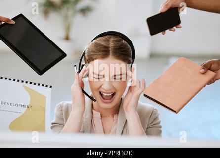 Stress, Burnout und überlastete Frau bei der Arbeit in einem modernen Büro. Weibliche Callcenter-Mitarbeiterin überwältigt mit der ganzen Arbeit ihrer Callcenter-Kollegen mit Angst und Kopfschmerzen am Arbeitsplatz. Stockfoto