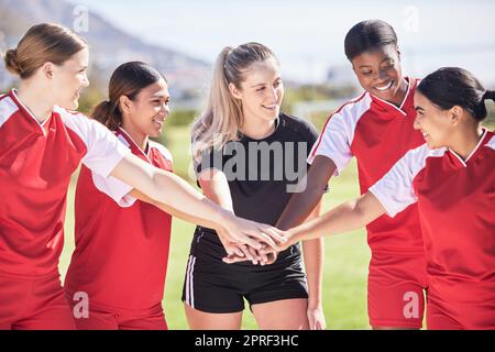 Nur weibliche Fußballmannschaft, die sich vor einem Spiel oder Wettkampf in Einheit, Unterstützung und Vertrauen zusammenhält. Glückliche Gruppe oder Team von Frauen Fußballspielern auf einem im Kreis stehenden Feld Stockfoto