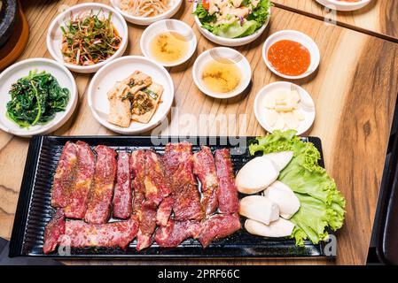 Rindfleisch zum Grillen auf dem Herd serviert mit Gemüse- und Suppenholztisch Stockfoto