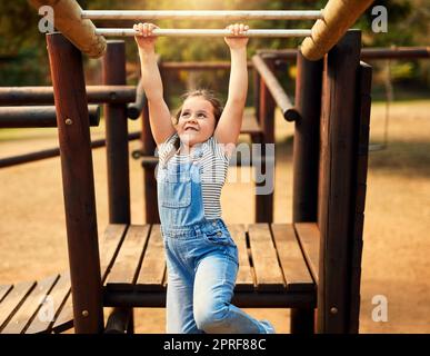 Spielen ist eine der beliebtesten Lernmethoden für Kinder. Ein kleines Mädchen spielt im Dschungel-Fitnessstudio im Park. Stockfoto