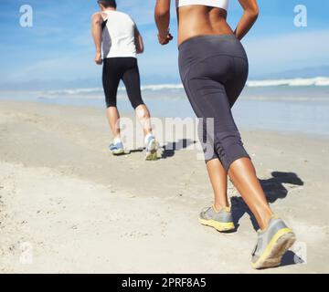 Zusammen fit zu werden. Zwei Leute Rennen am Strand Stockfoto