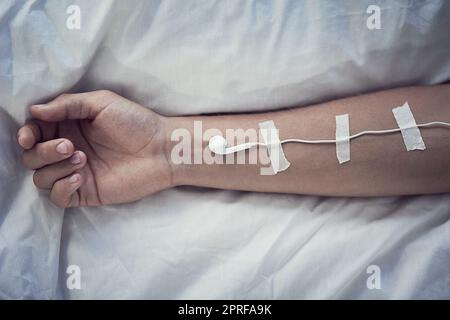 Musik rettete mir das Leben. Ohrhörer wurden auf einen ausgestreckten Arm von nicht erkennbaren Personen aufgeklebt. Stockfoto