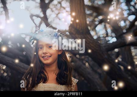 Kinder sehen immer die Magie im Leben. Porträt eines kleinen Mädchens, das draußen spielt. Stockfoto