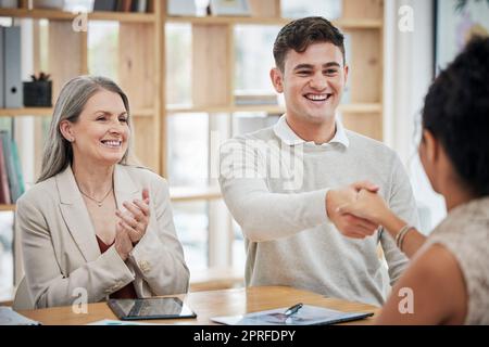 Glückliche Geschäftsleute, die sich die Hand schütteln, sich in einem Büro treffen und begrüßen. Glücklicher Profi, der mit seinem Chef über eine Beförderung oder einen Job spricht. HR gratuliert ambitionierten Mitarbeitern, klatscht und feiert Stockfoto