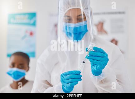 Impfstoff, Injektion und medikamentöse Heilung für Covid, Affen-Pocken und ebola mit einem Arzt, einer medizinischen Fachkraft oder medizinischem Fachpersonal. Frontline-Arbeiter im Schutzanzug Vorbereitung für die Injektion von Klinik- oder Krankenhauspatienten Stockfoto