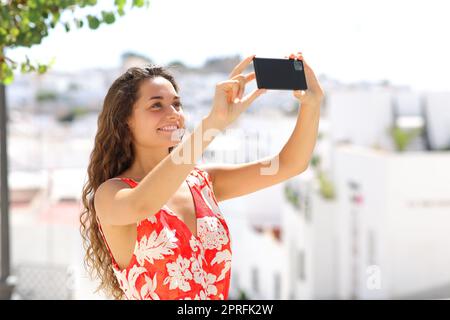 Touristen fotografieren mit dem Telefon in einer spanischen weißen Stadt Stockfoto
