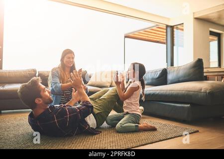 Lassen Sie jeden Moment zusammen zählen. Eine glückliche Familie von drei spielen ein klatschende Spiel zusammen zu Hause. Stockfoto