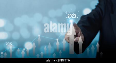 Geschäftsmann berühren Pfeil und 2023 Währung kopieren Raum background.Business Finance Wachstum Erfolg Prozess Investition wirtschaftlichen Markt Konzept. Stockfoto