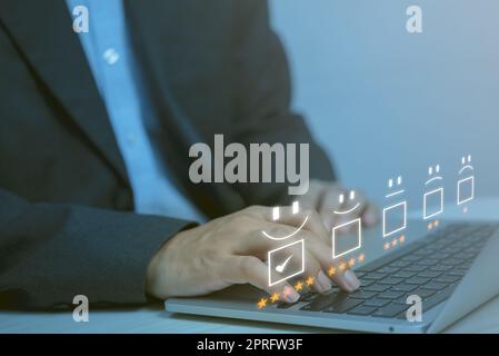 Zufriedenheitsumfrage und Kundenservice-Konzept.Geschäftsmann mit Computer-Notebook mit Smiley-Gesicht-Symbol 5 Sterne. Stockfoto
