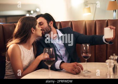 Ich möchte, dass die Welt weiß, dass du meine bist. Ein junges Paar, das ein Selfie auf einem romantischen Date nimmt. Stockfoto