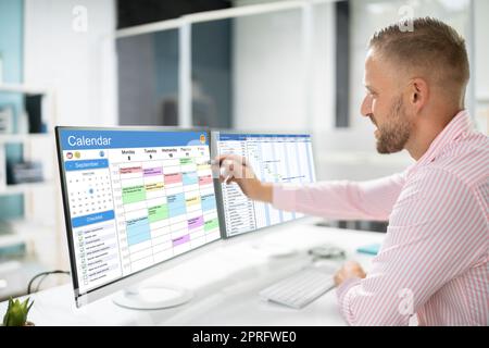 Mitarbeiter, Der Am Kalenderplan Arbeitet Stockfoto