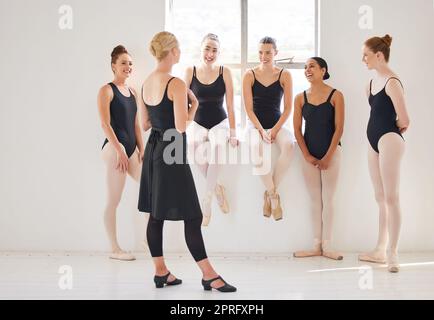 Ballettlehrer spricht im Unterricht mit Schülern und Unterhaltung im Theater. Ballerina-Trainer und Beziehung zu jungen Tänzern im Klassenzimmer. Klassisches Tanzschultraining und Studiolehrer Stockfoto