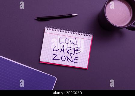 Handschriftlicher Text Low Carb Zone. Word for Healthy Diät for Loss Weight Eating more Proteine Zucker Free Notizbuch mit wichtigen Nachrichten auf dem Schreibtisch mit Kaffee und Stift. Stockfoto