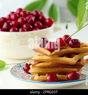 Stapel gebackener belgischer Waffeln mit reifen roten Kirschen, Frühstück. Stockfoto