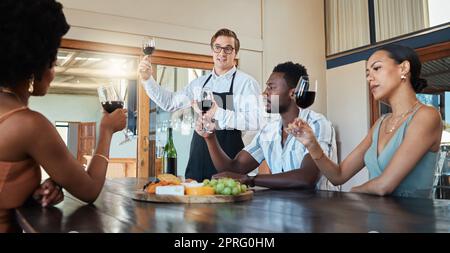 Weinprobe, Freunde und Wein in einem Restaurant oder Weinberg, um mehr über Traubenanbau und -Produktion zu erfahren. Gruppe mit einem Weinglas in der Hand, während der Kellner über eine Rotweinmischung spricht, bevor sie trinken Stockfoto