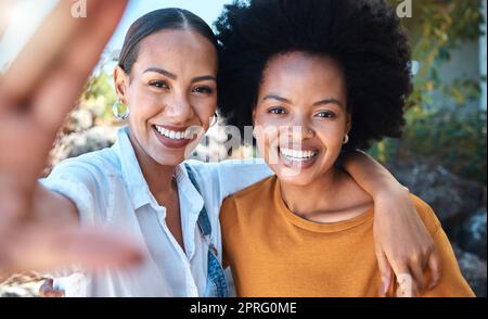 Gesicht von Freunden, die Selfie machen, im Naturpark glücklich sind und sich im Sommer draußen mit einem Lächeln umarmen. Schwestern fotografieren, Menschen Erinnerungen und Porträts von der Familie in einem grünen Garten Stockfoto