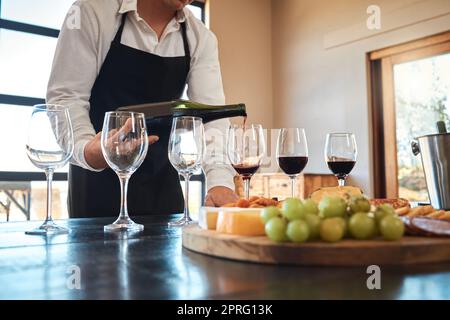 Gastfreundschaft, Industrie und luxuriöser Weinservice mit Kellner in Gläsern, bereiten Sie sich auf eine Weinprobe im Restaurant vor. Professionelle Sommelier-Einrichtung für feines Dining-Erlebnis mit Alkohol Stockfoto