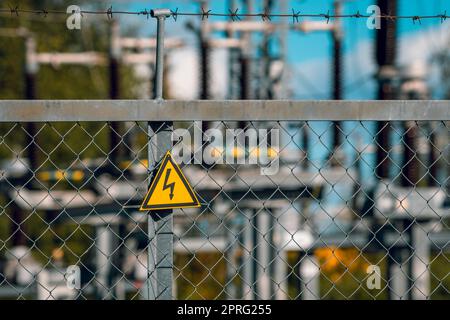 Warnschild für elektrische Gefahren am Zaun einer Hochspannungs-Unterstation. Stockfoto