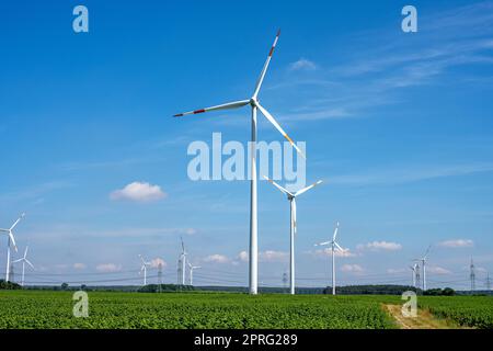 Windkraftanlagen zwischen landwirtschaftlichen Feldern in Deutschland gesehen Stockfoto