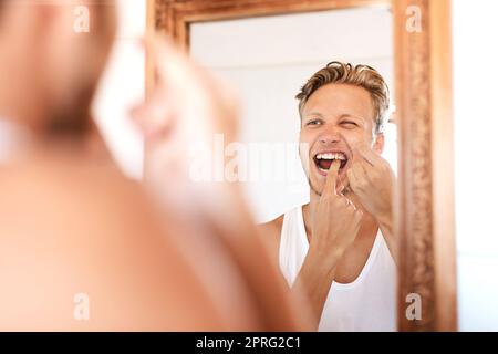 Denn Bürsten allein reicht nicht. Ein junger Mann, der sich zu Hause die Zähne putzt. Stockfoto