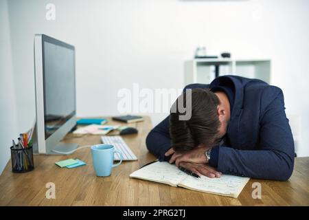 Ein gestresster Geschäftsmann wurde an seinem Schreibtisch ohnmächtig. Stockfoto