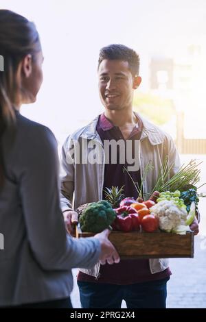 Eine weitere frische und schnelle Lieferung. Ein Kurier, der eine Lebensmittelzustellung an einen Kunden. Stockfoto