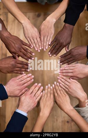 Alle Hände an Deck. Eine Aufnahme einer Gruppe von nicht identifizierbaren Geschäftsleuten, die mit ihren Händen im Büro einen Kreis bilden. Stockfoto