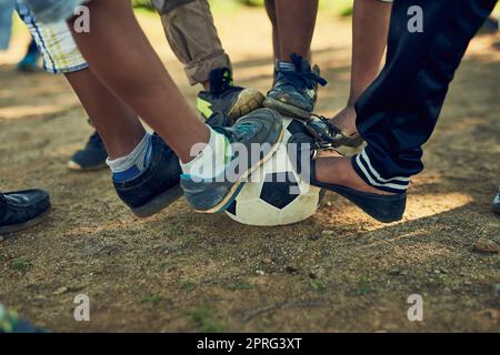 Es ist Zeit für ein Spiel. Eine Gruppe von Kindern, die auf einem Fußballplatz auf einem Feld draußen zusammen stehen. Stockfoto