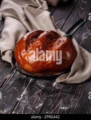 Nahaufnahme von duftendem, hausgemachtem Brot auf einem dunklen Holztisch. Stockfoto