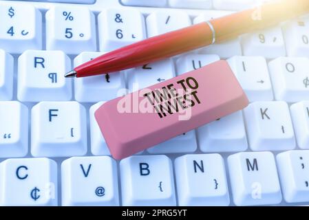 Schreiben mit Anzeige von „Time to Invest“ (Zeit für Investition). Wort für die Schaffung von Kapital, das andere Güter produzieren kann wichtige Nachricht auf dem Schreibtisch mit Stift und Gummi verfasst. Stockfoto