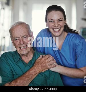 Helfen Sie Senioren, ein Leben in Lebensqualität zu führen. Eine Krankenschwester, die neben ihrer älteren Patientin steht. Stockfoto